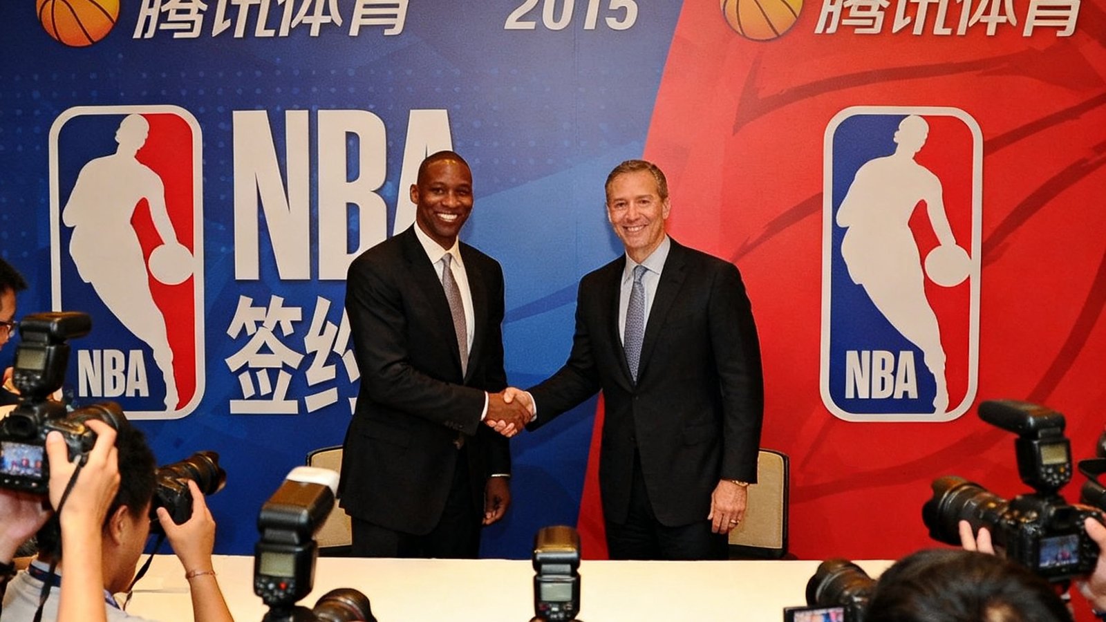 2015年腾讯体育官网与NBA签约仪式的现场照片，双方代表在签约台前握手，背景板上印有腾讯体育和NBA的标志，众多媒体记者举着相机记录这一历史性时刻